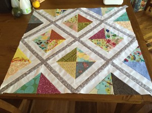 Finished quilt top with grey diagonal sashing